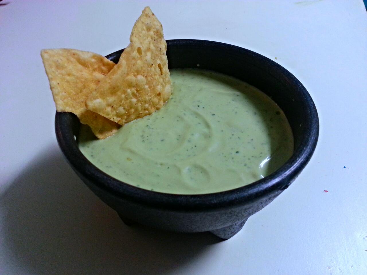 smooth green guacamole salsa with tortilla chips